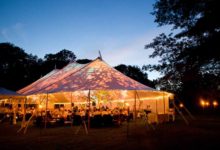 A rented wedding tent all lit up in the evening