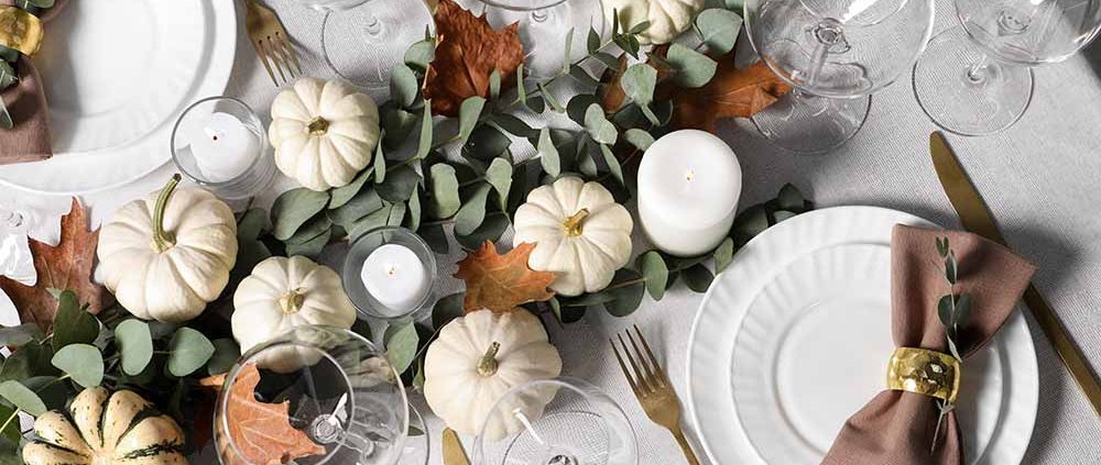 An elegant Thanksgiving table with a white tablecloth and brown linen napkins