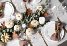 An elegant Thanksgiving table with a white tablecloth and brown linen napkins