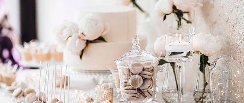 A beautiful wedding cake table decorated with glass and flowers