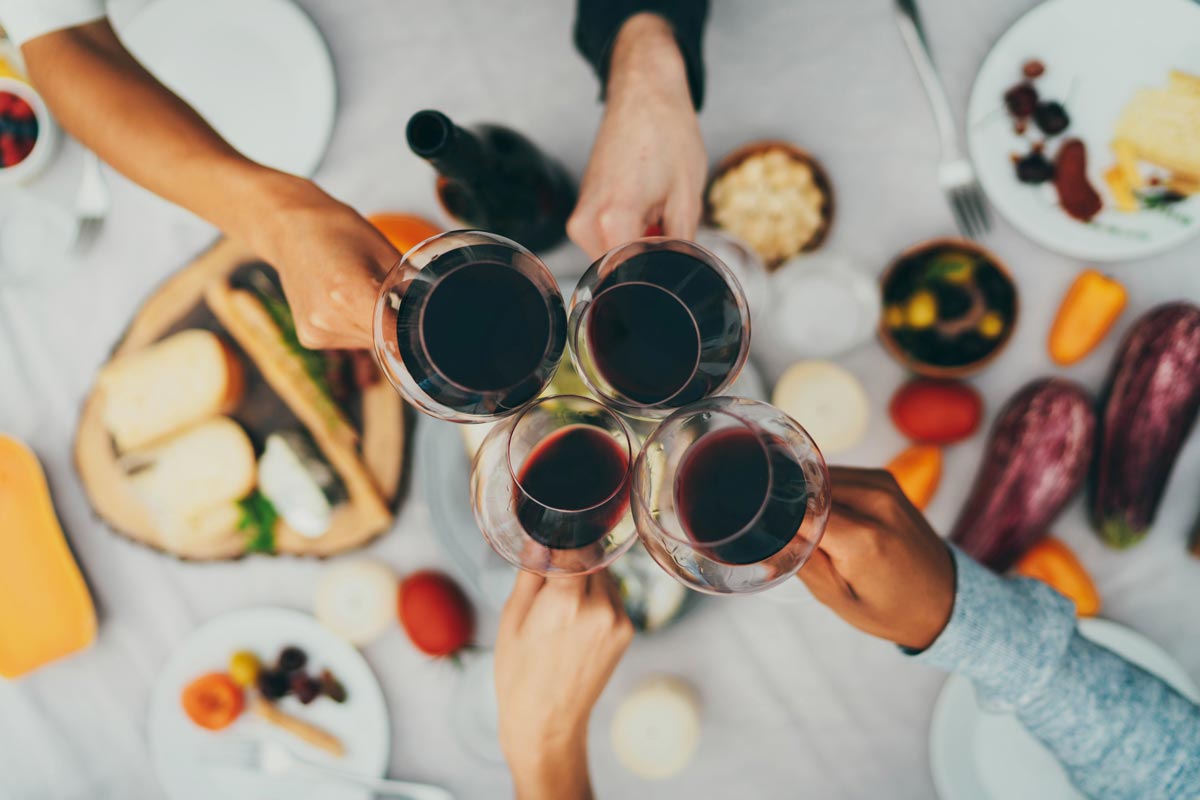 Overhead view of a toast at a birthday party, with the table spread beneath the raised glasses