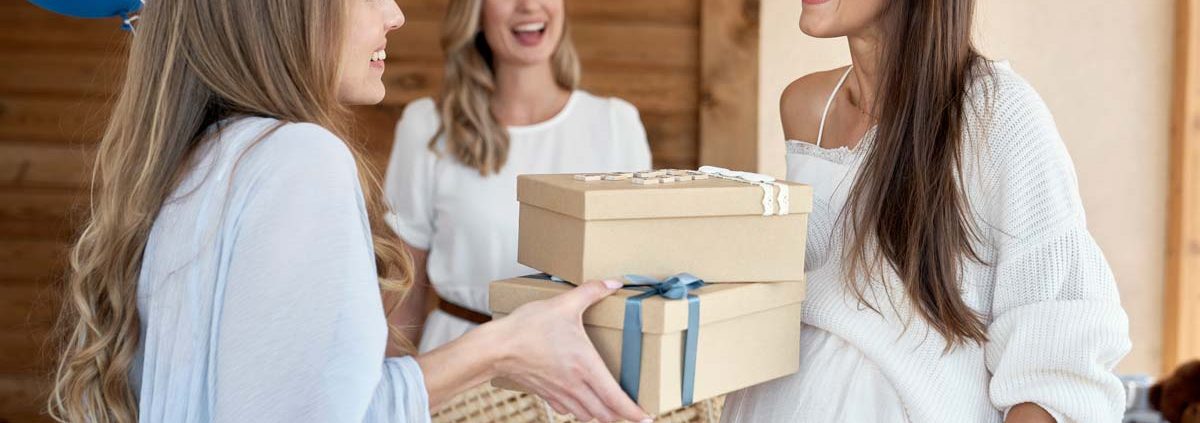 Smiling guests greet the mother-to-be at a baby shower