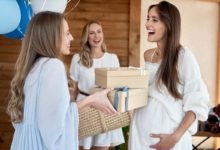 Smiling guests greet the mother-to-be at a baby shower