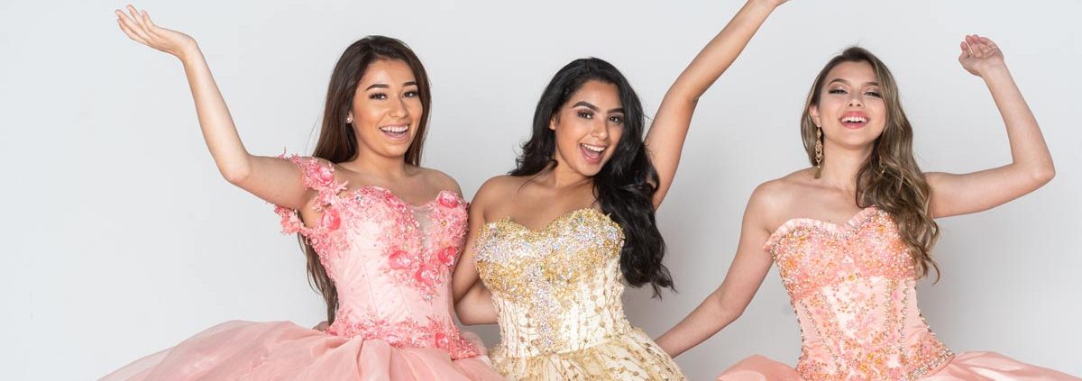 Three smiling teenage girls in their quince gowns