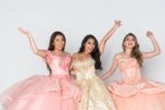 Three smiling teenage girls in their quince gowns