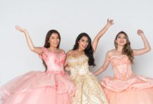 Three smiling teenage girls in their quince gowns