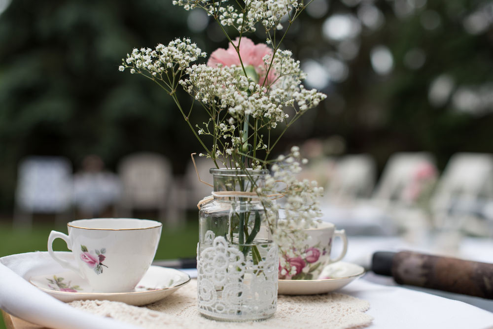 A teacup and flower table setting at a bridal shower